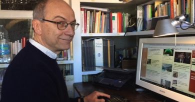 Il giornalista ambientale Antonio Cianciullo seduto alla sua scrivania, con il computer davanti e la libreria sullo sfondo