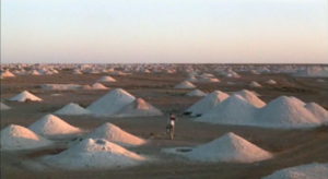 Un uomo che passeggia tra le dune del deserto tratto dal film "dove sognano le formiche verdi"