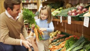 Un papà fa la spesa biologica insieme a sua figlia.